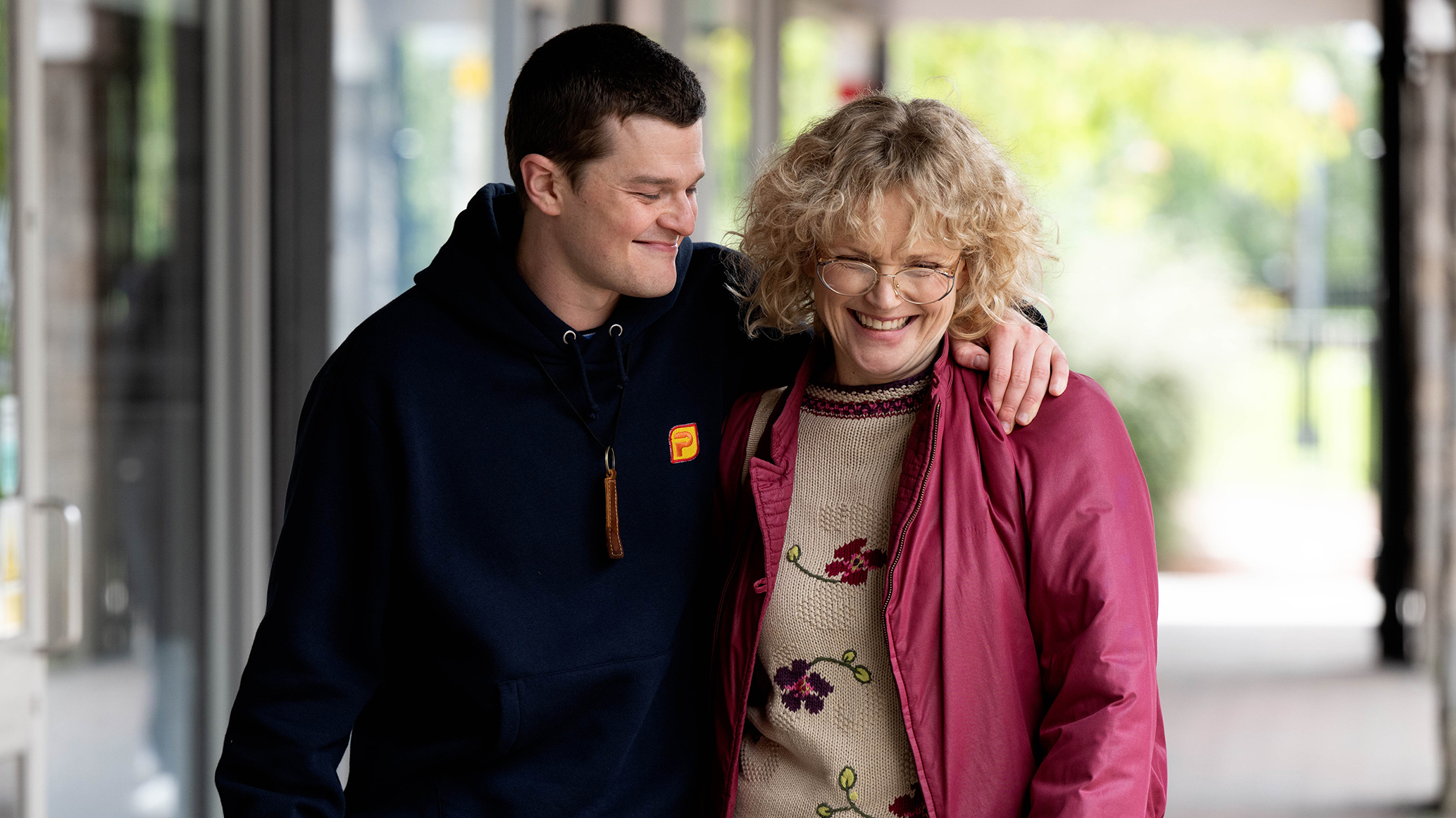 Actors Robert Aramayo and Maxine Peake in character as John Davidson and Dottie Achenbach walking arm in arm in a shot from the movie I Swear.jpg