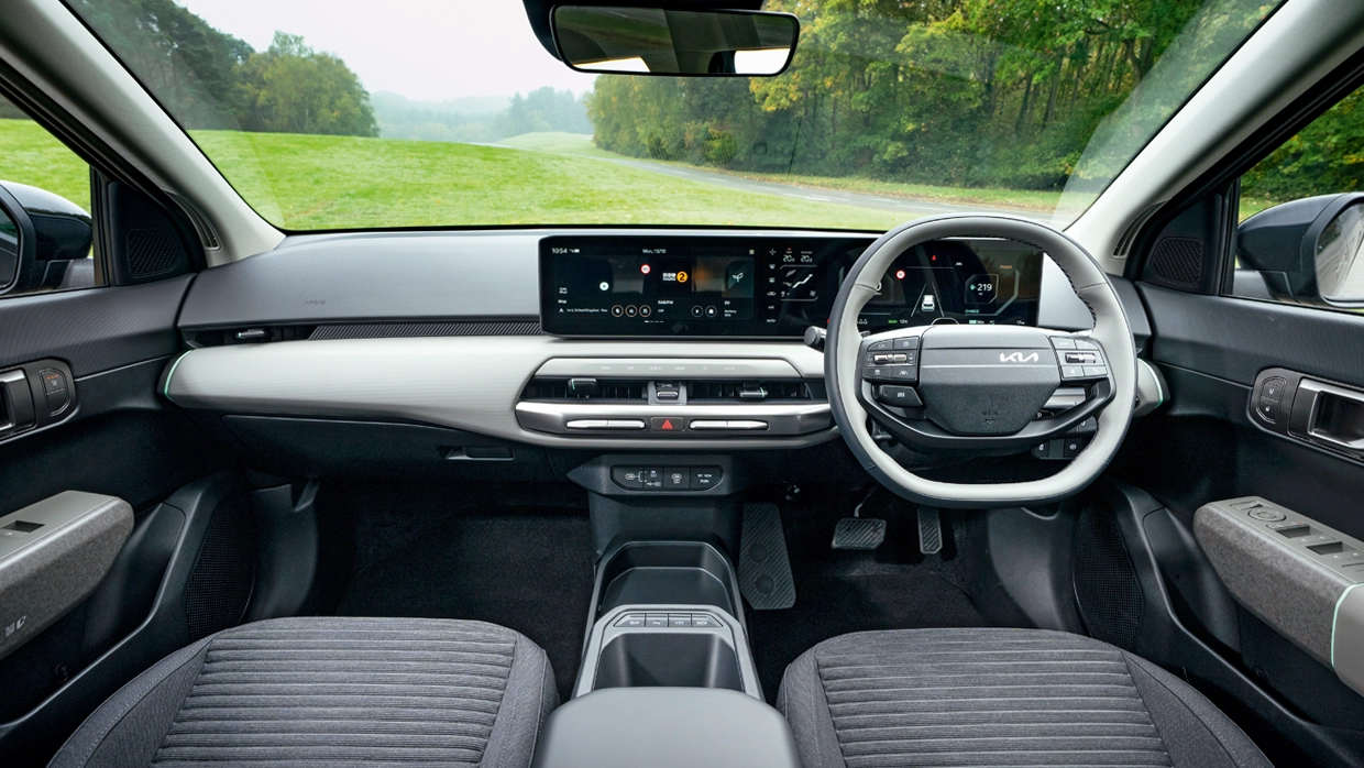 a-view-of-the-steering-wheel-and-dashboard-inside-the-kia-ev4.webp