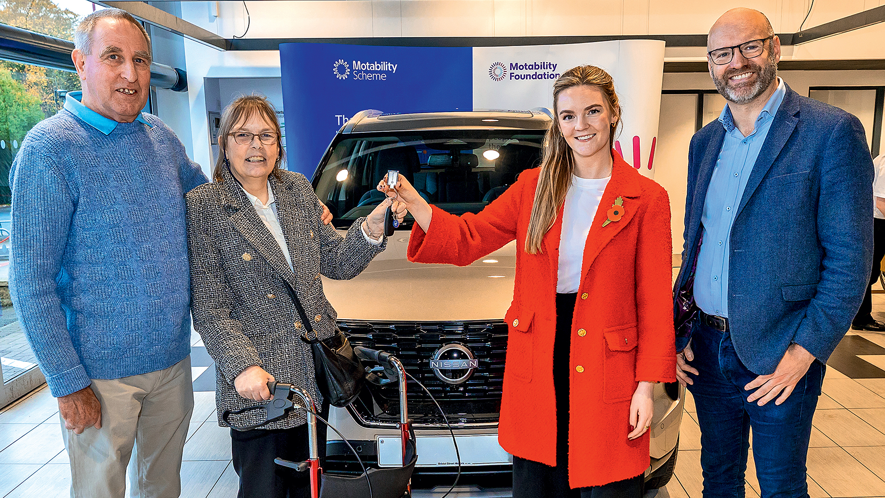 Four people stood in front of a car