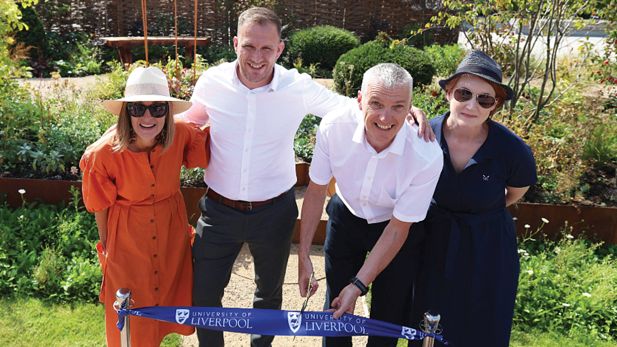 A a line up of people celebrating the ADHD Foundation Garden from Chelsea Flower Show finding a new home at The University of Liverpool 