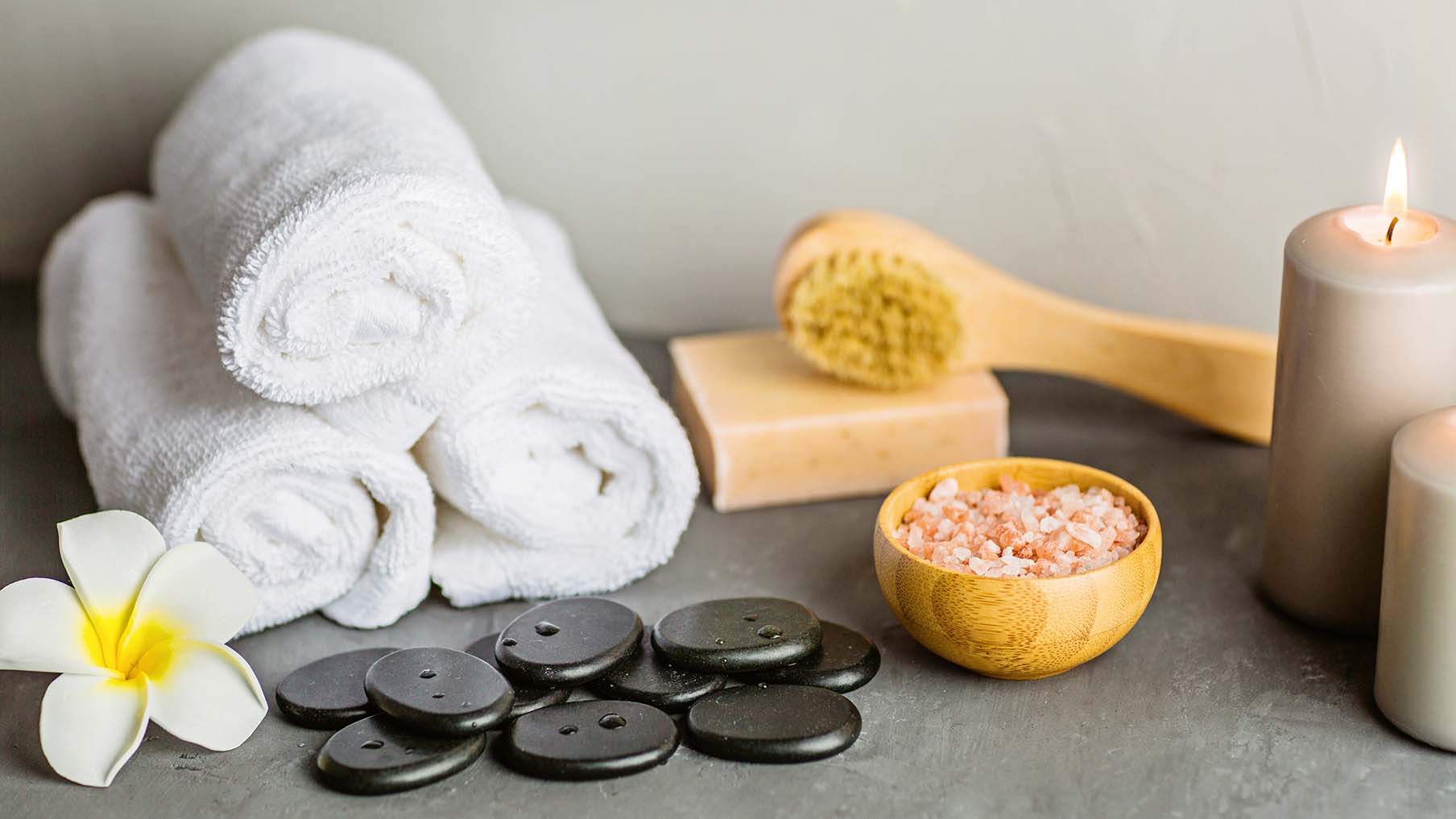Stones, towels, salts and candles arranged for spa treatments