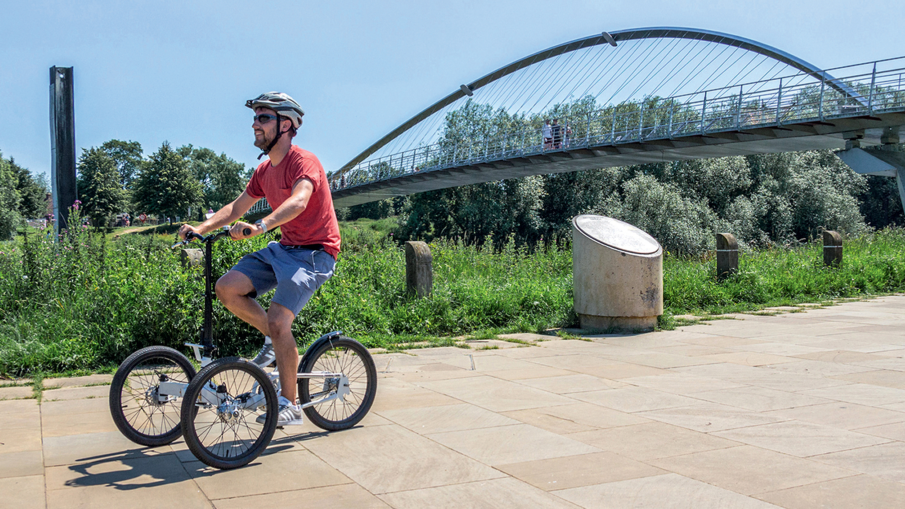 A man riding a tricycle on a public path
