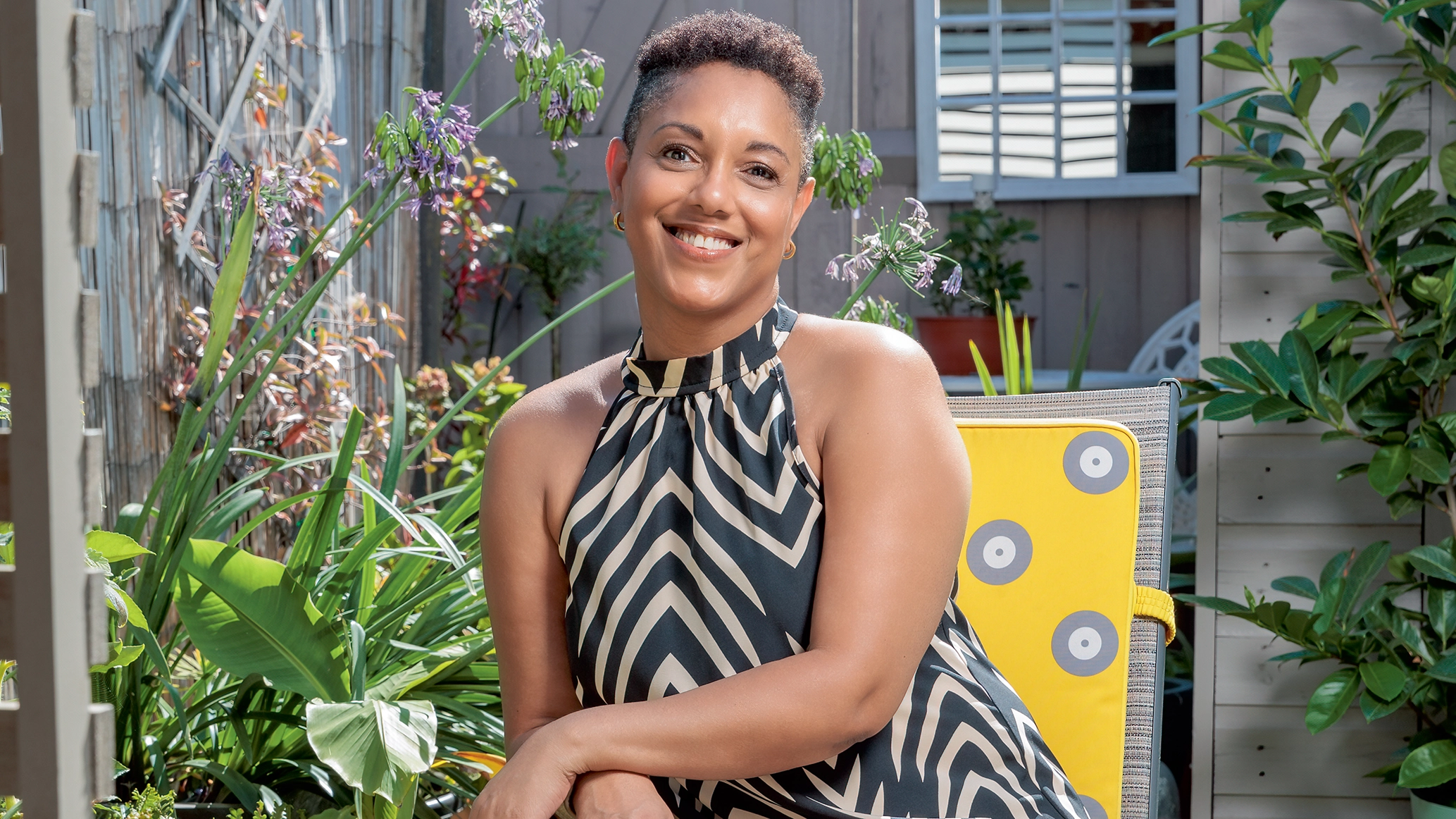 A photo of Andie sitting down wearing a dress and smiling at the camera