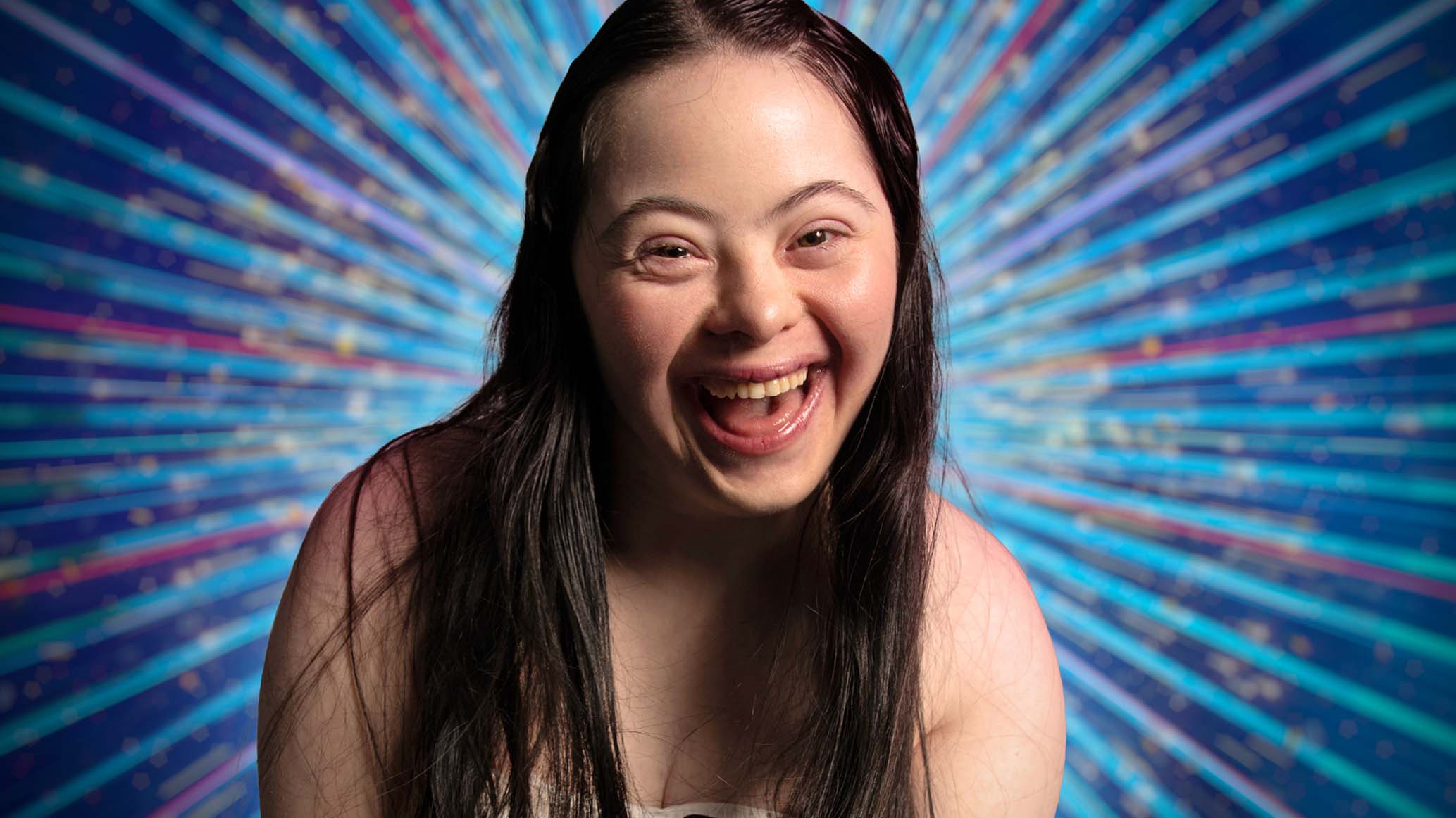 Ellie smiling to the camera with glitter around her 