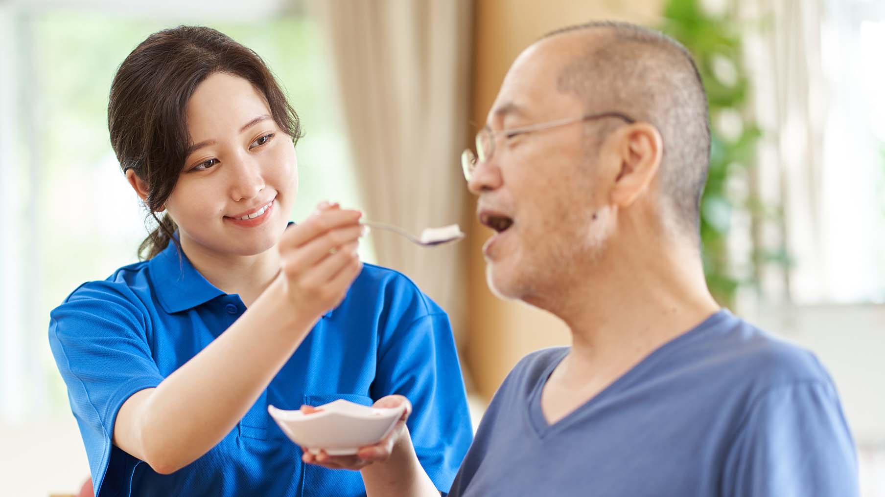 A care worker feeding their patient